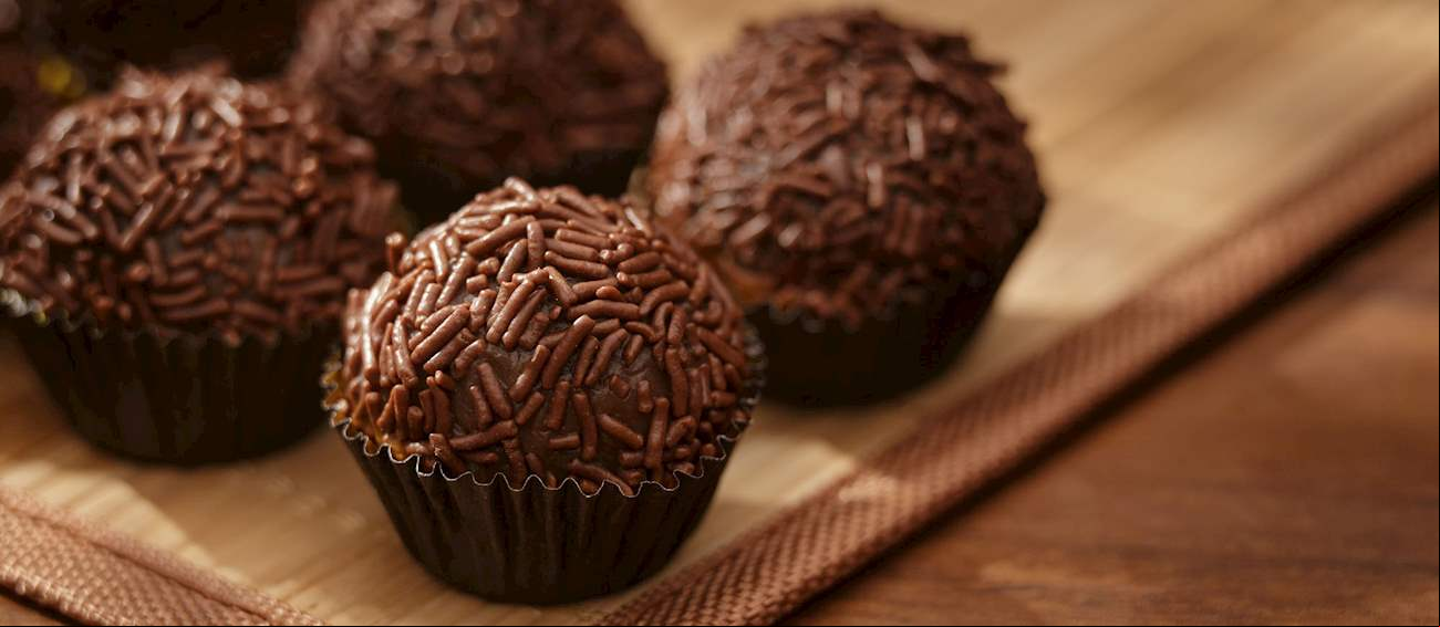 Brigadeiro - Doce feito com leite condensado, chocolate em pó e manteiga, moldado em bolinhas e coberto com chocolate granulado.