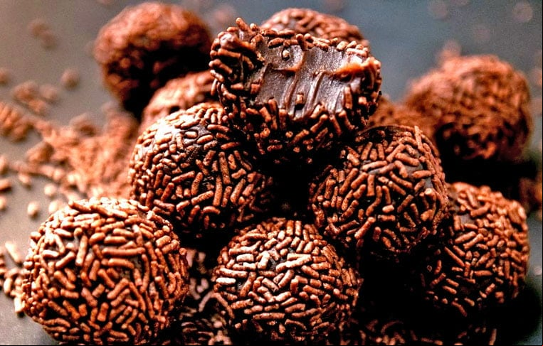Leve ao fogo médio uma a com o leite condensado, o chocolate em pó e a manteiga, mexendo sempre até desgrudar do fundo da a. Deixe esfriar, molde bolinhas e e-as no chocolate granulado antes de servir.